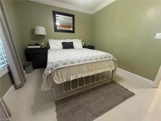 Bedroom featuring ornamental molding and light tile patterned floors