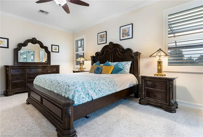 Owners bedroom featuring ceiling fan and crown molding, plantation shutters and new carpet 2023