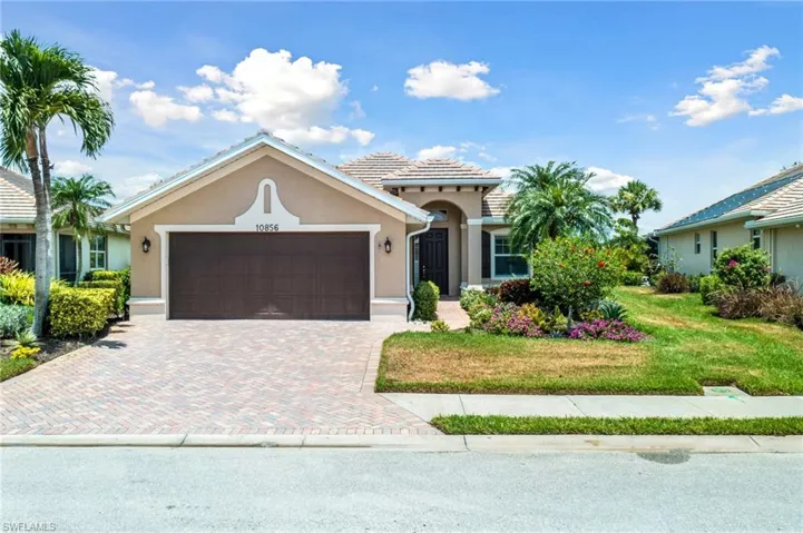 View of front of home with lovely landscaping and paved driveway