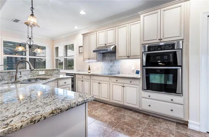 Kitchen featuring Bosch induction cook top decorative light fixtures, cream cabinetry, tile floors, and ornamental molding