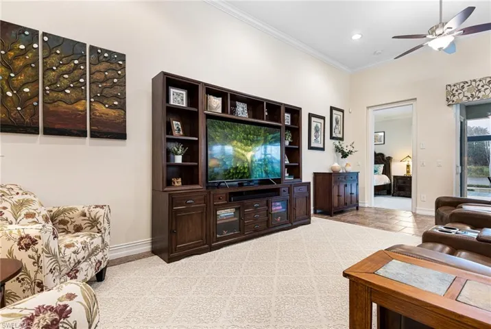 Great room with crown molding, and ceiling fan