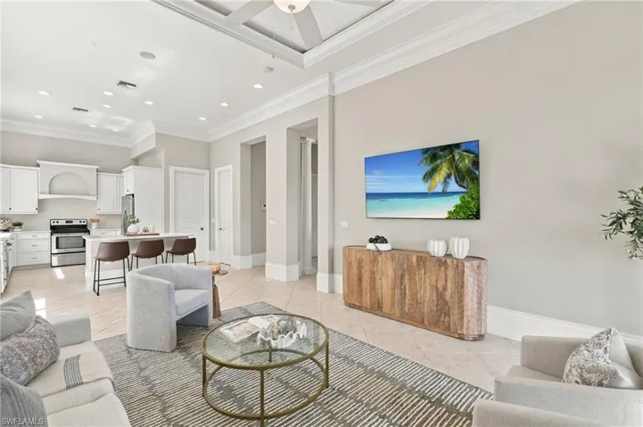 High ceilings with recessed lighting, crown molding, coffered ceiling detail, tile flooring, and custom cabinetry