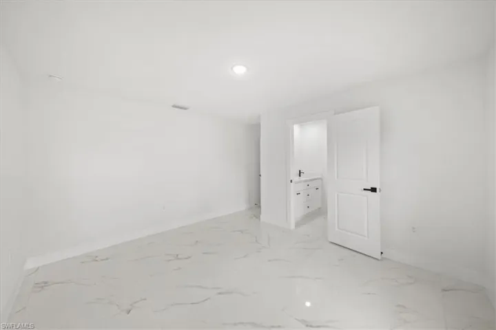 Unfurnished room featuring baseboards, light marble finish floors, and recessed lighting