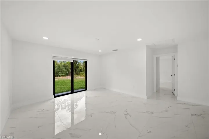 Spare room featuring light marble finish flooring, baseboards, and recessed lighting