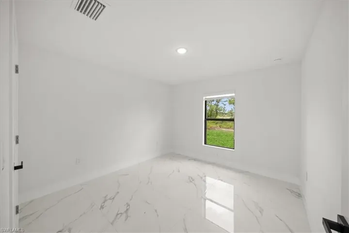 Spare room with baseboards, light marble finish flooring, and recessed lighting