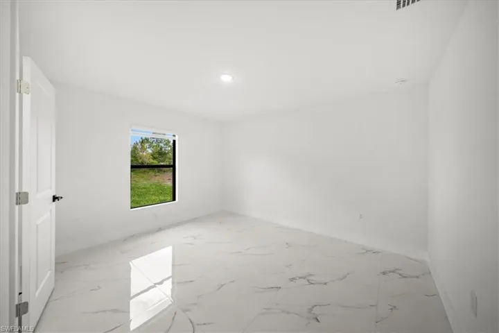 Empty room with baseboards, light marble finish flooring, and recessed lighting