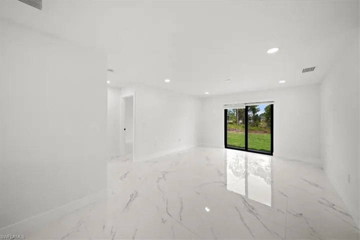 Empty room with light marble finish flooring, baseboards, and recessed lighting