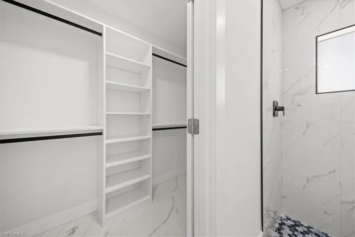 Spacious closet featuring marble look tile flooring
