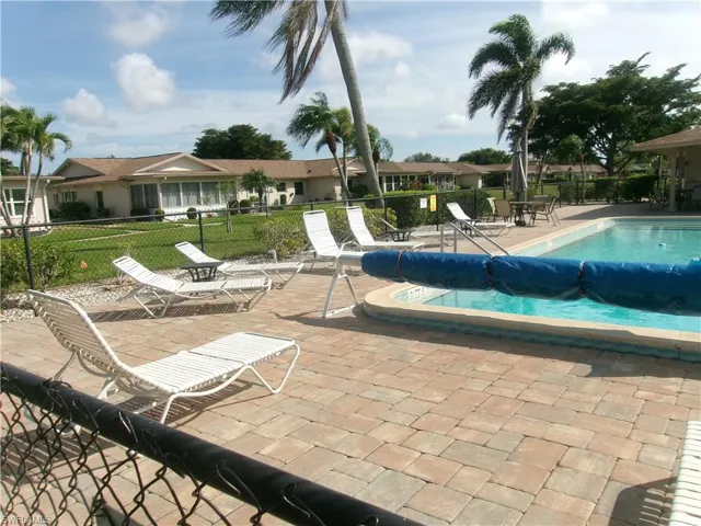 Community pool featuring a patio area and fence