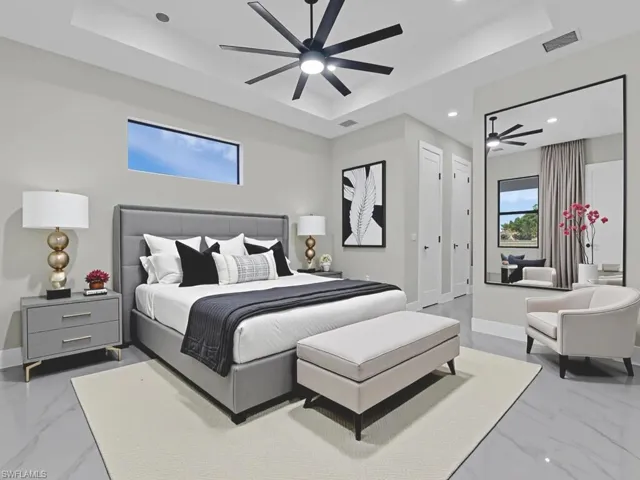 Bedroom featuring a tray ceiling, marble finish flooring, and recessed lighting