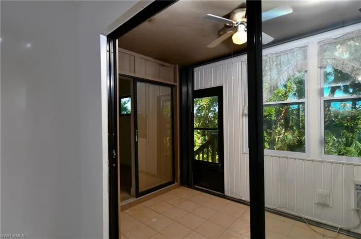 Back LanaiRear 4 season lanai with ceiling fan and light tile patterned floors