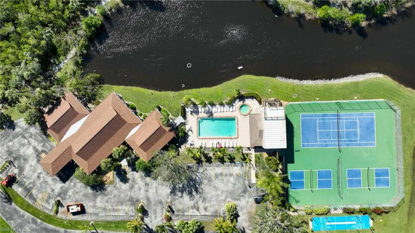Bird's eye view of community buildings, pool, spa, lake, courts and parking.