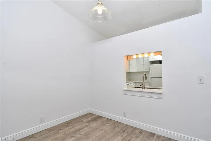 Dining Area with a textured ceiling, wood-type tile flooring, lofted ceiling and pass thru