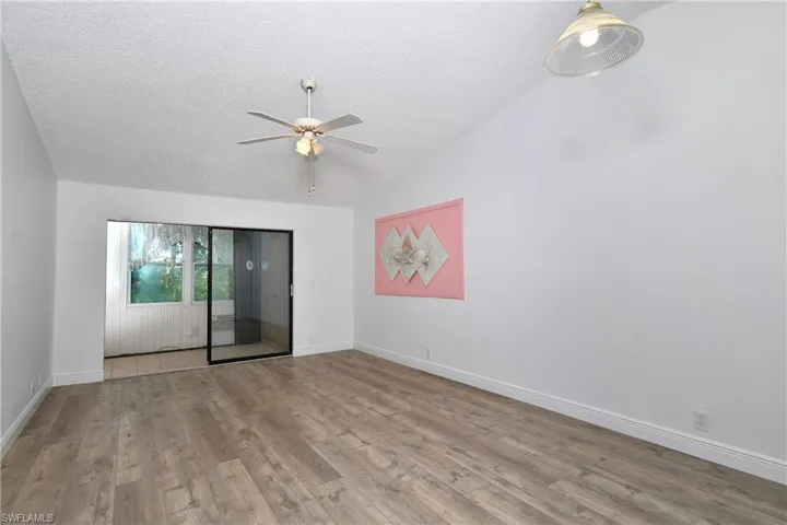 Living Room/Dining Area featuring a textured ceiling, vaulted ceiling, light tile / wood-style flooring and ceiling fan