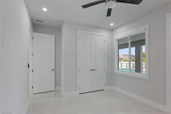 This room features light grey walls, white trim, and light-colored tile flooring