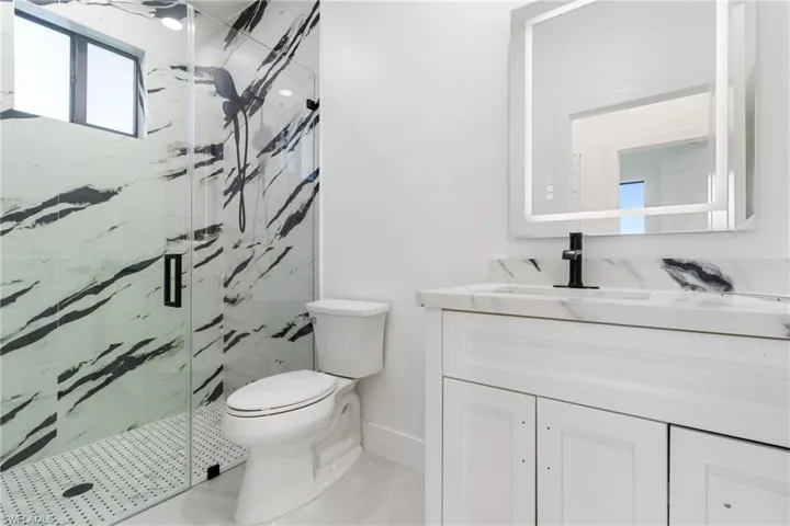 Full bathroom with a marble finish shower and vanity