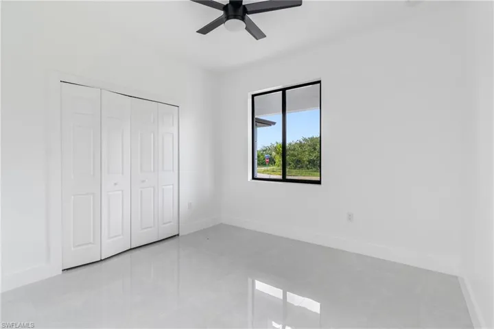 Unfurnished bedroom with light tile patterned floors, a closet, and ceiling fan