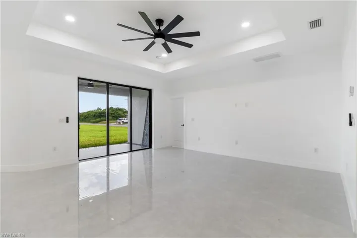 Spare room featuring a tray ceiling, a ceiling fan, and recessed lighting