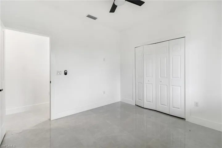 Unfurnished bedroom with ceiling fan and a closet