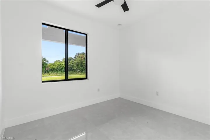Unfurnished room with baseboards and ceiling fan