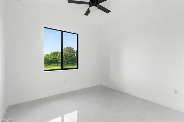 Empty room featuring baseboards and a ceiling fan