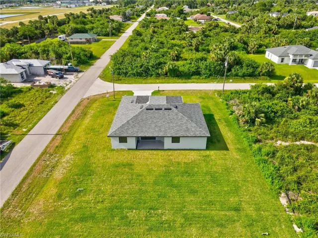 Aerial view of property and surrounding area featuring a tree filled landscape