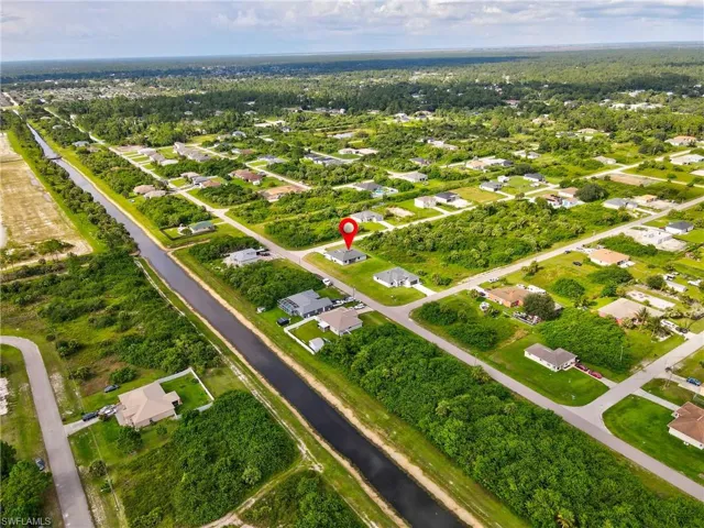 Aerial view of property and surrounding area with nearby suburban area