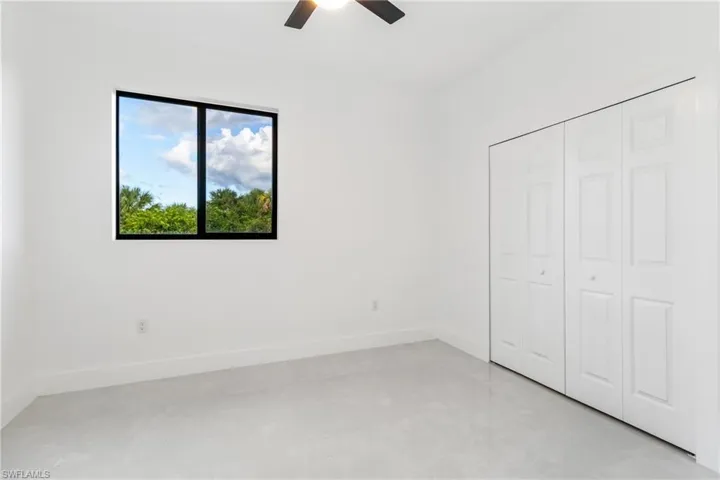 Unfurnished bedroom with ceiling fan, a closet, and light tile patterned flooring