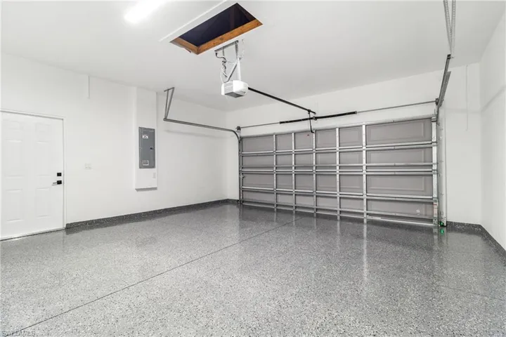 Garage with electric panel and a garage door opener