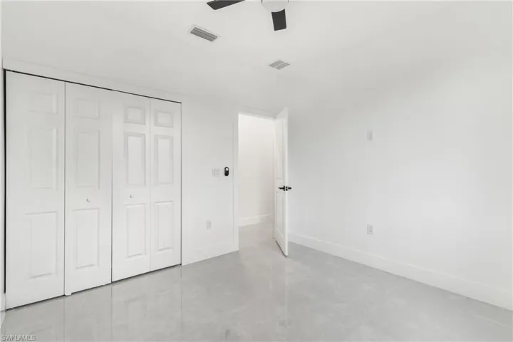 Unfurnished bedroom featuring a closet, a ceiling fan, and light tile patterned floors