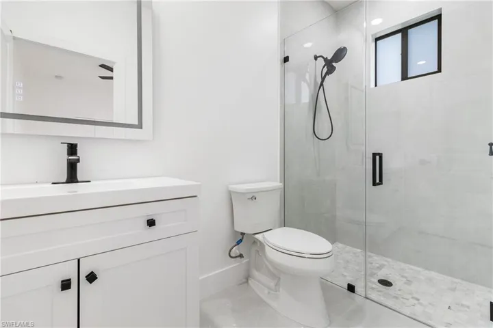 Full bath with vanity, a stall shower, and light tile patterned floors