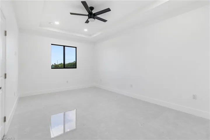 Unfurnished room featuring a raised ceiling, recessed lighting, and ceiling fan