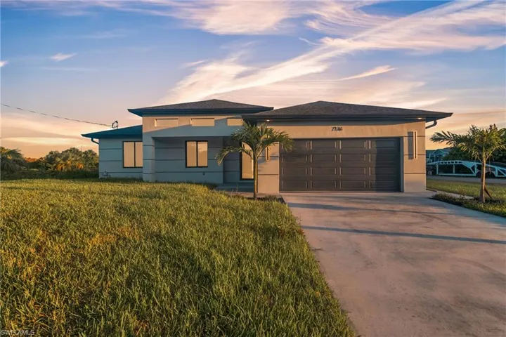 View of front of home with concrete driveway, an attached garage, and stucco siding