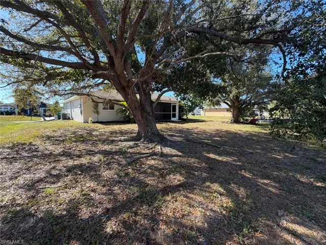 View of grassy yard with a sunroom