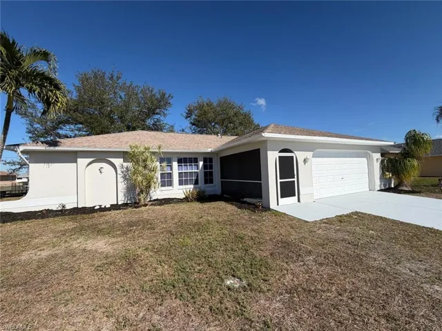 Single story home featuring a front yard, concrete driveway, an attached garage, a sunroom, and roof with shingles