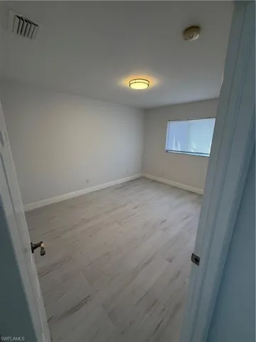 Unfurnished room featuring baseboards and a smoke detector