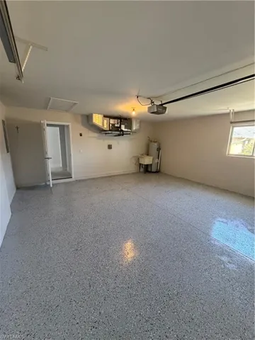 Garage featuring water heater and a garage door opener