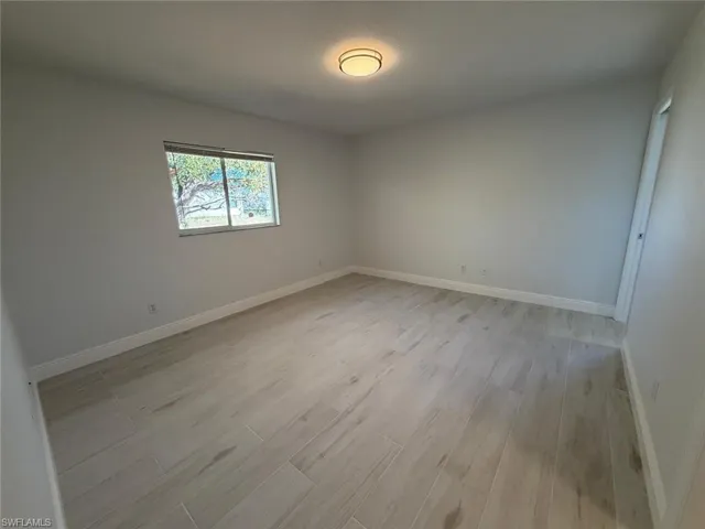 Empty room with light wood-type flooring and baseboards
