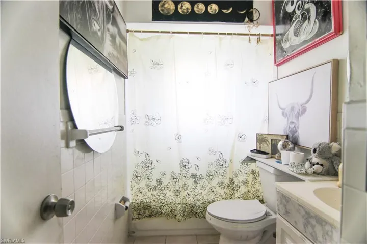 Bathroom with vanity, tile patterned flooring, and shower / tub combo