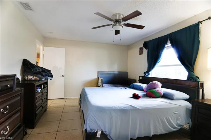 Bedroom with light tile patterned flooring and ceiling fan