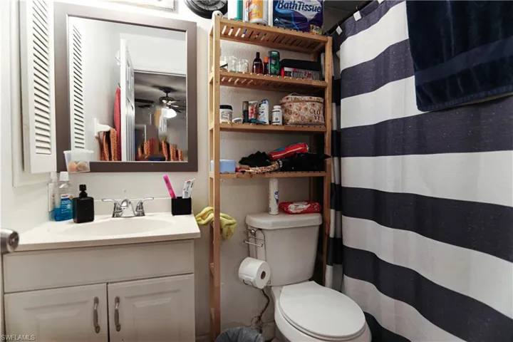Bathroom featuring vanity, a shower with shower curtain, and ceiling fan
