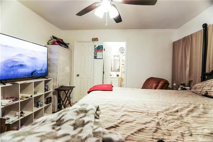 Bedroom featuring ensuite bath and a ceiling fan