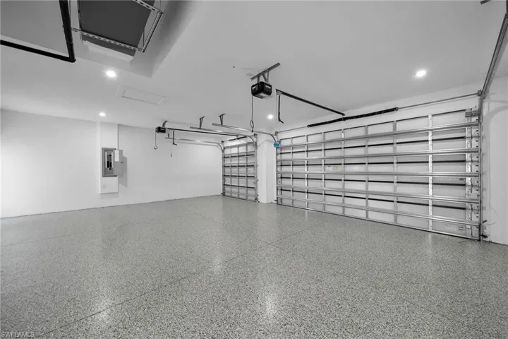 Garage featuring a garage door opener and electric panel
