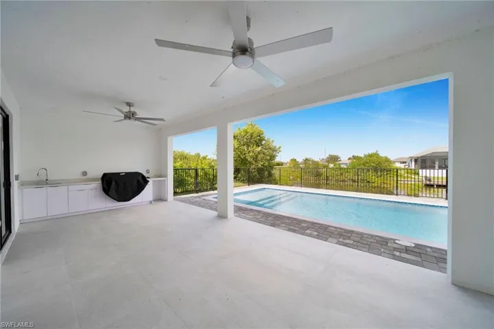 View of swimming pool with a patio, area for grilling, sink, and ceiling fan