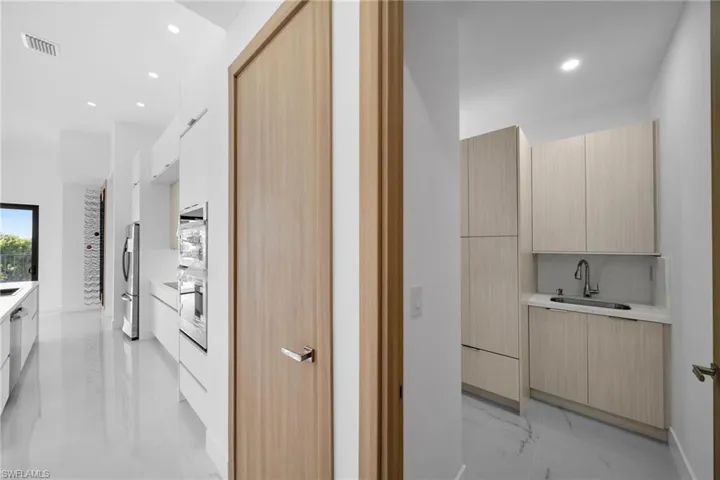 Corridor with sink and light tile patterned flooring