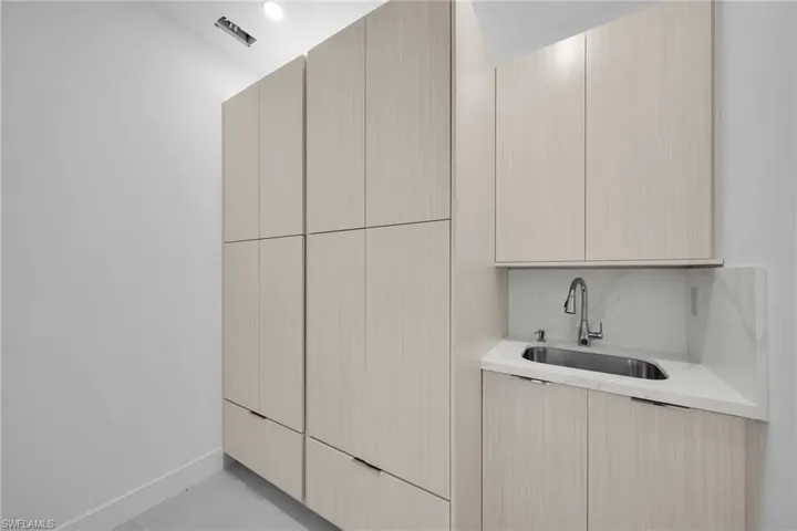 Washroom with sink and light tile patterned floors