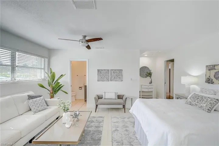 Tiled bedroom with ceiling fan and ensuite bathroom
