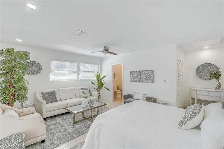 Tiled bedroom featuring ceiling fan, a closet, and connected bathroom