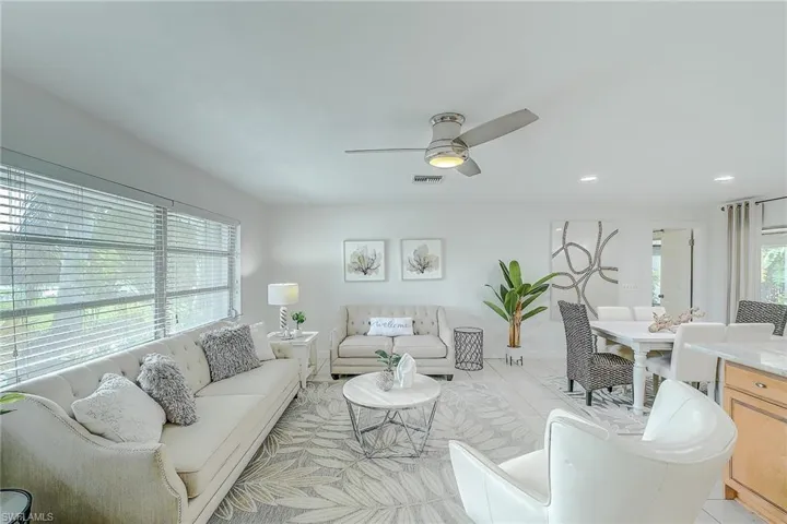 Living room featuring ceiling fan, plenty of natural light, and light tile patterned flooring