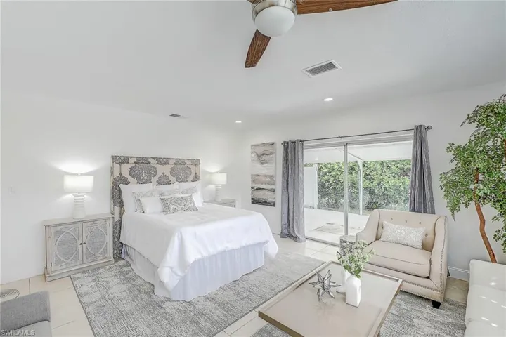 Bedroom featuring light tile patterned floors, ceiling fan, and access to outside